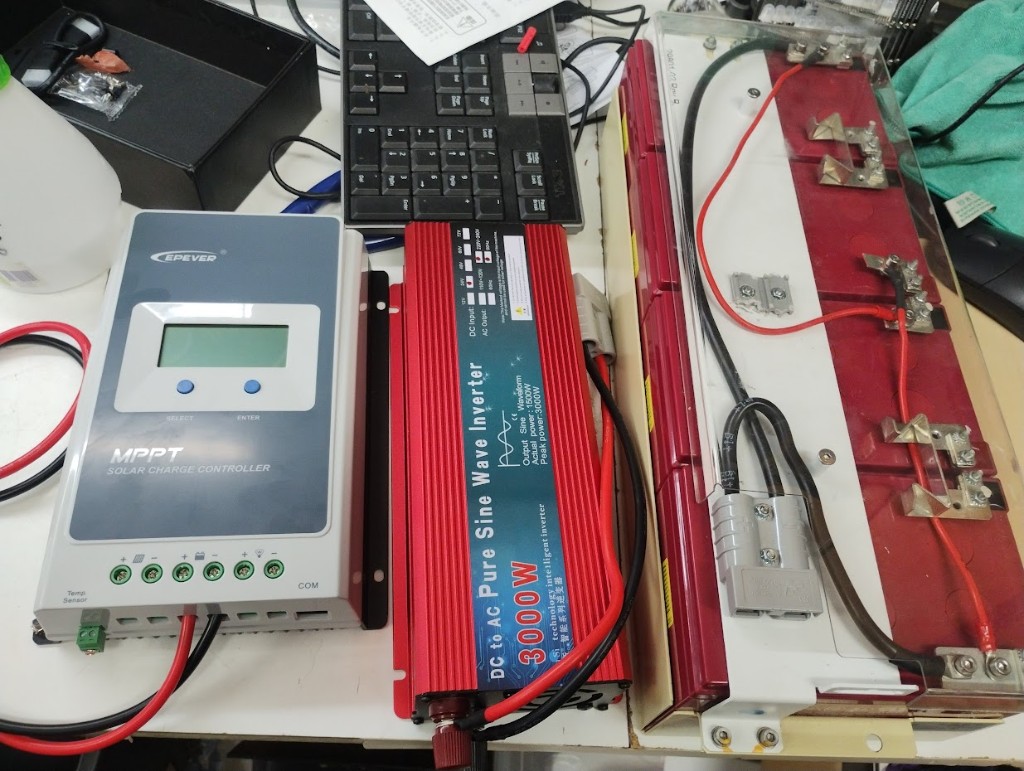 Epever MPPT solar charge controller wired to a salvaged battery pack on a workbench
