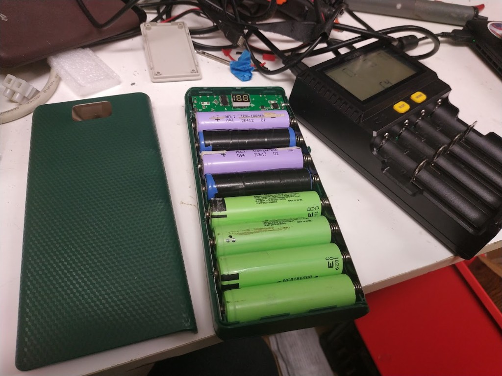 DIY power bank case filled with salvaged 18650 lithium cells beside a MiBOXER charger